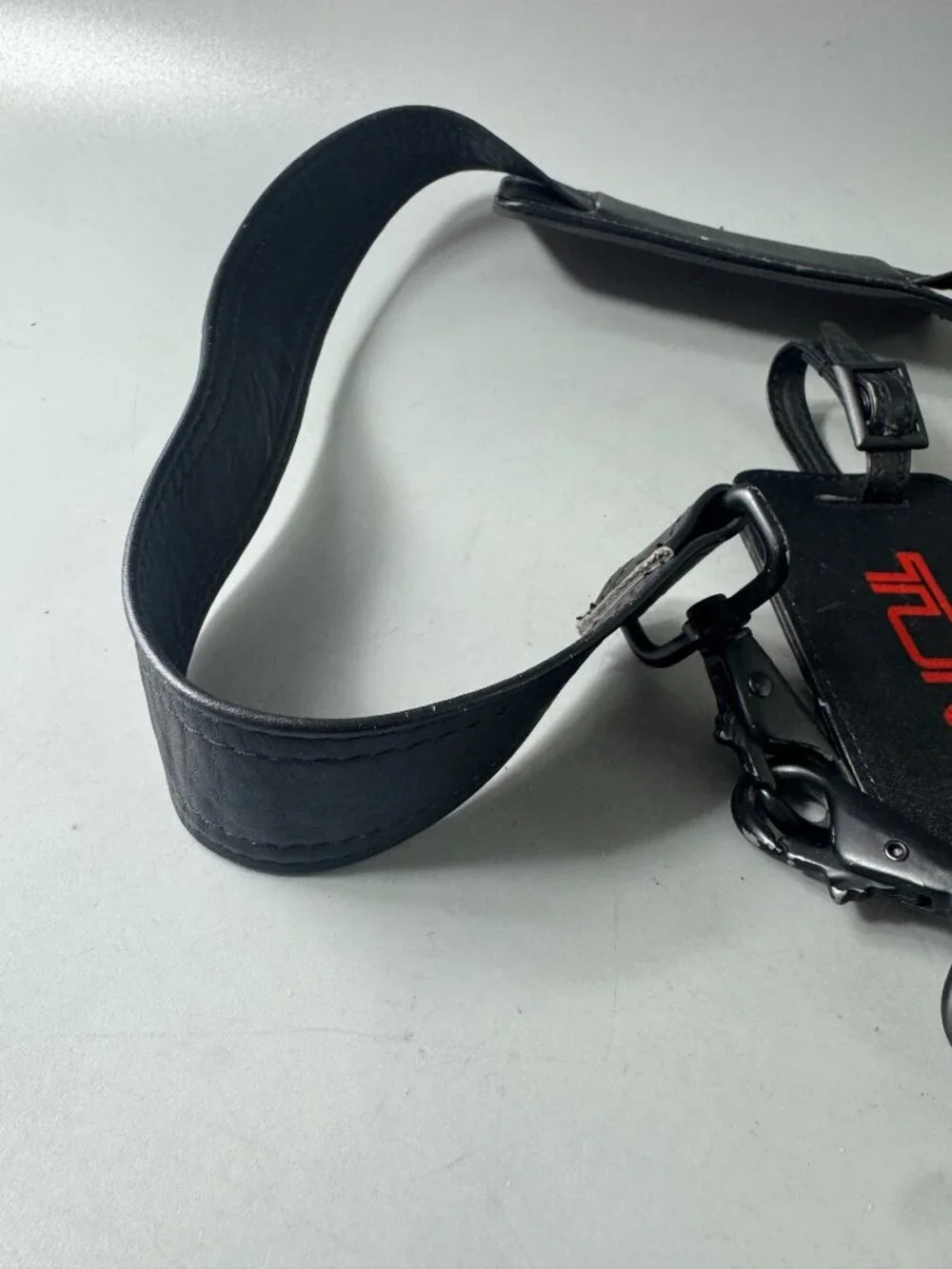 A Bundle of Two (2) Vintage Tumi Black Leather Strap and Travel Tag
